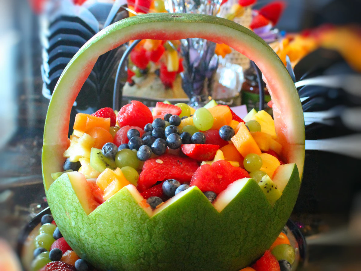 Ensalada fresca servida con frutas y hojas verdes